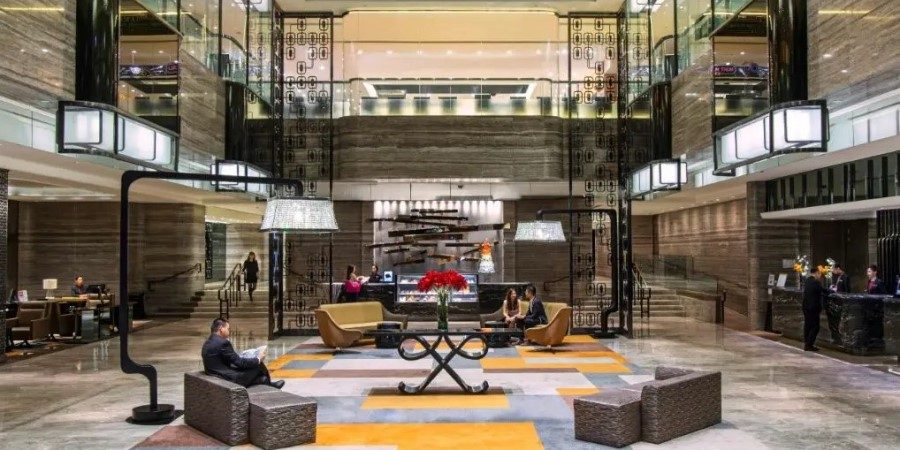 Interior view of the Royal Plaza Hotel lobby showcasing a grand glass ceiling that enhances natural light.